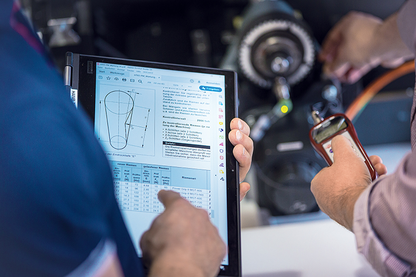 EMCO Mitarbeiter führen eine Messung an der geöffnten CNC Maschine durch
