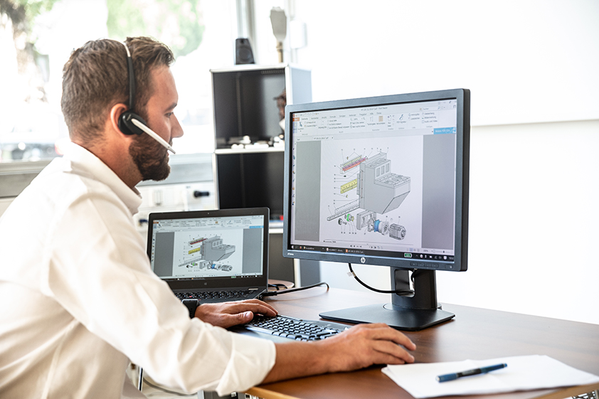 EMCO Hotline-Techniker arbeitet am PC mit Headset