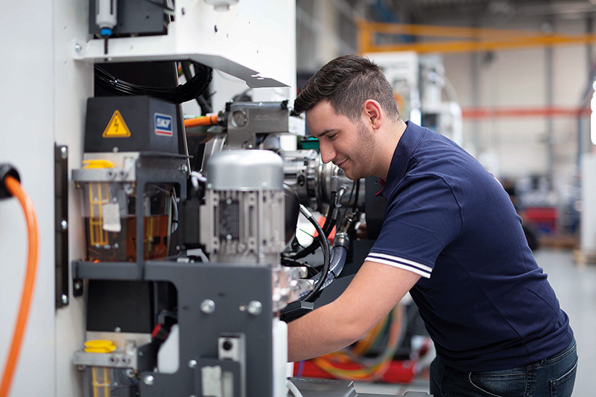 EMCO Mitarbeiter arbeitet an offener Maschine